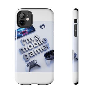 Pode incluir: Capa de telefone branca com o texto "I'm a mobile gamer" em letras prateadas 3D. A capa apresenta um smartphone exibindo um jogo de corrida, fones de ouvido sem fio e dois controles de jogo.