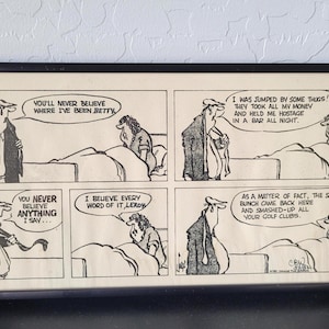 May include: Black framed comic strip with four panels. The comic strip has text bubbles with the phrases: "You'll never believe where I've been Betty", "I was jumped by some thugs!", "You never believe anything I say...", "I believe every word of it Leroy", and "As a matter of fact, the same bunch came back here and smashed-up all your golf clubs."