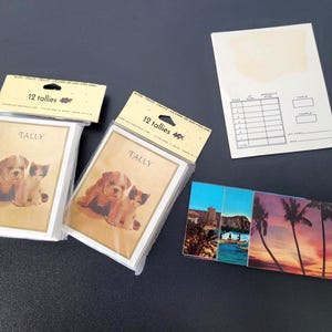 May include: Two packs of "12 tallies" cards with a puppy and kitten image, and the word "TALLY". Also, a white score card and a small stack of postcards with scenic images.