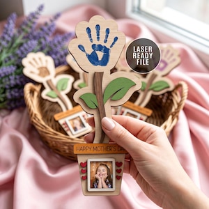 Könnte beinhalten: Blumenförmiger Fotorahmen aus Holz mit einem Handabdruck auf der Blüte. Die Blume hat grüne Blätter und einen Topf mit einem Foto und dem Text "HAPPY MOTHER'S DAY". Das Bild ist mit "LASER READY FILE" beschriftet.