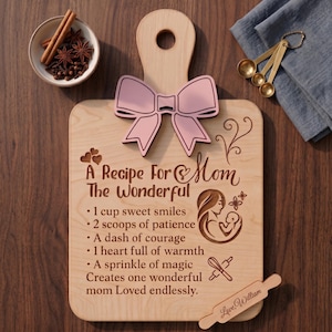 May include: Wooden cutting board with a light pink bow and the text "A Recipe For Mom". The recipe includes ingredients like sweet smiles and patience. A small rolling pin and a bowl of spices are also visible.