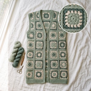 May include: A sleeveless vest constructed from crocheted granny squares in shades of sage green, forest green, and cream. The garment features a V-neckline and a ribbed hem. Included are two skeins of yarn, a wooden crochet hook, and metal scissors.