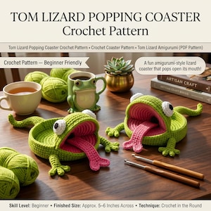 May include: Two green crochet lizard coasters with open mouths and pink tongues, accompanied by green yarn balls, a frog mug, and two wooden crochet hooks. The text reads TOM LIZARD POPPING COASTER Crochet Pattern, Beginner Friendly, and Finished Size: Approx. 5-6 Inches Across.