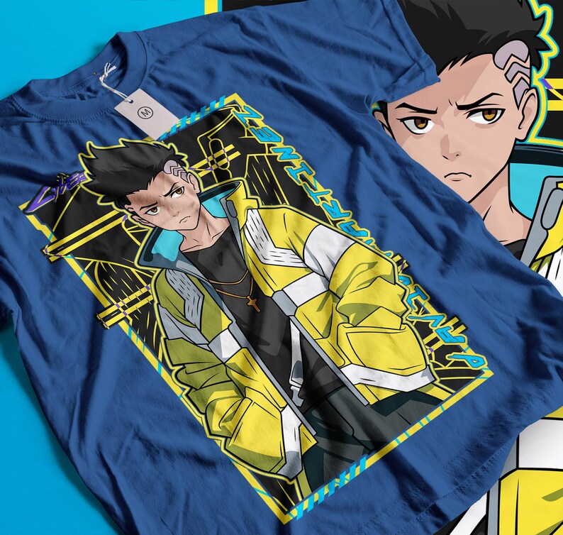 Pode incluir: Camiseta azul com um personagem de estilo anime usando uma jaqueta amarela e branca, uma camisa preta e um colar com uma cruz dourada. O design &eacute; emoldurado em amarelo e preto. Outra imagem do personagem &eacute; vis&iacute;vel.