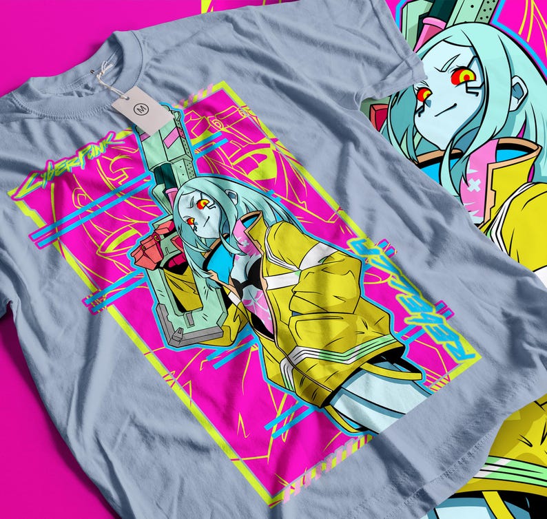 Op de afbeelding: Lichtblauw t-shirt met een opvallende afbeelding van een vrouwelijk personage met blauw haar, rode ogen en een gele jas, die een futuristisch wapen vasthoudt. Het ontwerp staat tegen een roze en gele geometrische achtergrond met het woord "Cyberpunk" in neon groen.