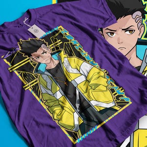 Pode incluir: Camiseta roxa com um personagem de anime estilizado usando uma jaqueta amarela e branca. O gr&aacute;fico inclui o rosto do personagem e a palavra "ART" em um design geom&eacute;trico. Uma etiqueta est&aacute; presa &agrave; camiseta.