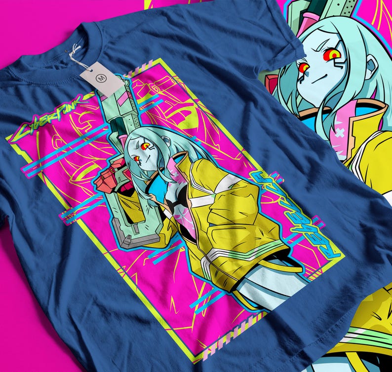 Op de afbeelding: Marineblauw t-shirt met een opvallend grafisch ontwerp. Het ontwerp toont een personage met lichtblauw haar, een gele jas en een wapen, tegen een roze en gele achtergrond. Het woord "CYBERPUNK" is zichtbaar.