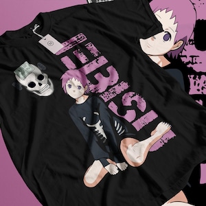 May include: Black t-shirt featuring a graphic of an anime character with pink hair and the word "ISEI" in pink. The shirt also has a skull graphic and a tag.