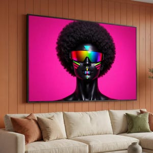 May include: A framed artwork featuring a stylized portrait of a person with black skin and a large afro. The person wears rainbow-colored sunglasses and has colorful geometric face paint against a bright pink background.