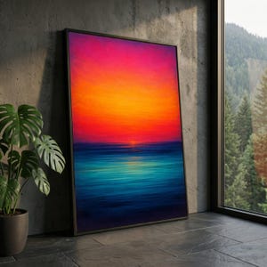 Puede incluir: Una impresión artística enmarcada que representa una vibrante puesta de sol sobre el océano. La obra de arte presenta un degradado de colores, que va de un cielo rosa y naranja brillante a un mar azul profundo. El marco es negro.
