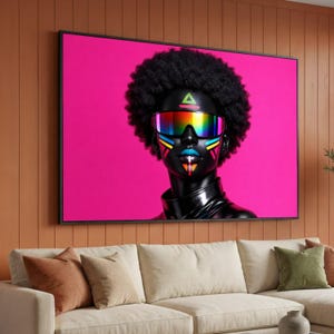 May include: A framed art print featuring a person with black skin, an afro, and rainbow-colored goggles. The person's face is adorned with colorful geometric designs. The background is a vibrant pink, and the artwork is displayed above a beige sofa.