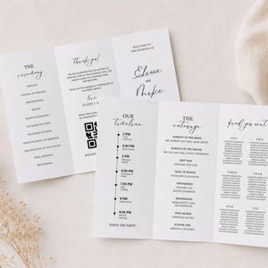 Könnte beinhalten: Weiße Hochzeitskarten mit schwarzem Text. Die Karten sind dreifach gefaltet und zeigen den Ablauf der Zeremonie, die Reihenfolge der Ereignisse und die Namen des Brautpaares. Auf weißem Untergrund.