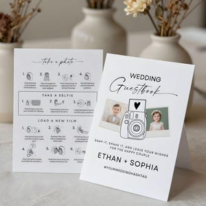 May include: White wedding guestbook card with a black line drawing of a camera and two photos. The text reads "Wedding Guestbook" and "Snap it, shake it, and leave your wishes for the happy couple". Also includes instructions on how to take a photo and a selfie.