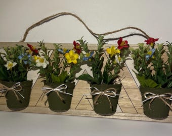 4つの小さな鉢植えの造花を飾った木製の壁掛け装飾