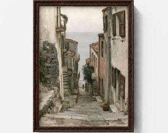 May include: A framed wall art print depicting a narrow stone staircase descending between weathered buildings toward a calm sea. The scene features muted earth tones, a small lone figure in the distance, and a dark brown wooden frame.