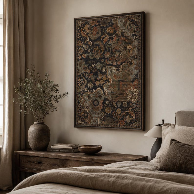 May include: A rectangular wall art piece featuring a dark, intricate floral and paisley pattern in shades of black, rust orange, and muted blue, enclosed in a thin dark frame. The artwork is displayed on a neutral wall above a wooden console table.
