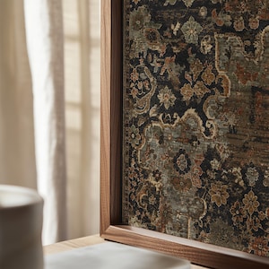 May include: A framed wall art piece featuring a dark, intricate floral and damask pattern in shades of black, muted green, and burnt orange. The artwork is encased in a smooth, medium-toned wooden frame with a visible grain, set vertically.