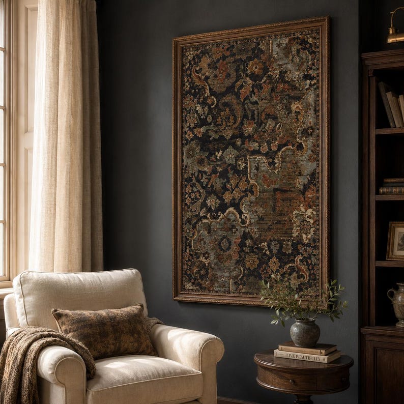 May include: A large rectangular wall art piece featuring a dark, intricate tapestry-style pattern in shades of black, rust orange, muted green, and cream, enclosed within a decorative brown wooden frame hanging on a dark gray wall.
