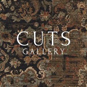 May include: A rectangular rug featuring a dark black background with an intricate floral pattern in shades of rust orange, muted green, and beige. The text CUTS GALLERY is printed in white in the center of the rug over the floral design.