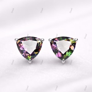 May include: A pair of stud earrings featuring triangular, iridescent gemstones. The gems display a spectrum of colors, including purple, green, and yellow, set in a silver metal. The earrings are displayed on a white background.