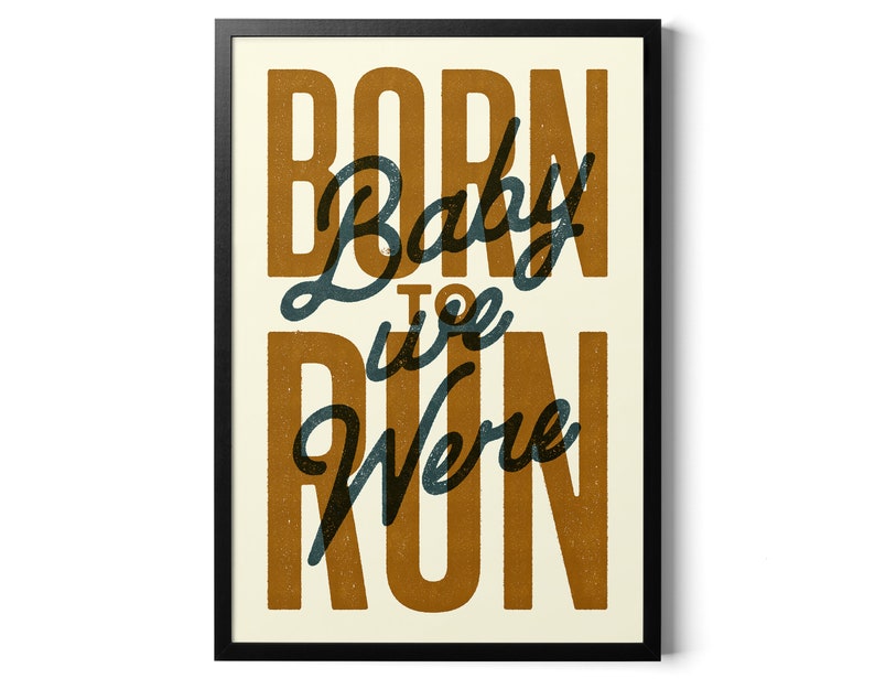 May include: A framed print with the text "Born to Run" in a vintage style font. The text is in a dark blue color with a brown background.