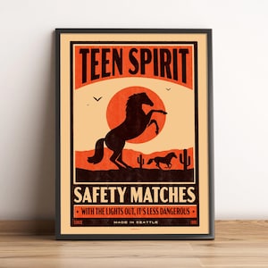 May include: Framed poster with a vintage design. The poster features a rearing horse silhouette against a sunset backdrop, with text that reads "TEEN SPIRIT" and "SAFETY MATCHES". The poster also includes the text "WITH THE LIGHTS OUT, IT'S LESS DANGEROUS" and "MADE IN SEATTLE".