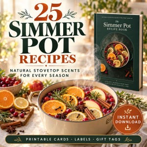 May include: A recipe book titled The Simmer Pot Recipe Book with a dark green cover, displayed next to a cream-coloured pot filled with simmering water, orange slices, cranberries, rosemary, and cinnamon sticks, with text reading 25 Simmer Pot Recipes.