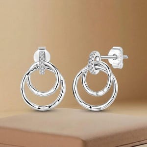 Pendientes de botón con círculos entrelazados y circonitas cúbicas en plata de ley 925.