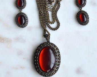 Conjunto de collar y pendientes vintage firmados por Avon Nina Ricci con cabujón rojo brillante.