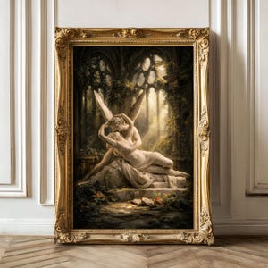 Puede incluir: Una impresión enmarcada de una escultura clásica que representa una figura alada abrazando a una figura reclinada. La obra de arte está ambientada en un entorno exuberante y cubierto de vegetación con elementos arquitectónicos. El marco dorado ornamentado añade elegancia.