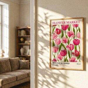 May include: A framed botanical print featuring a vibrant display of pink tulips against a cream background. The print is labeled "Flower Market" and "Botanical Series Tulips No. 2". The artwork is displayed on a beige wall in a well-lit room.