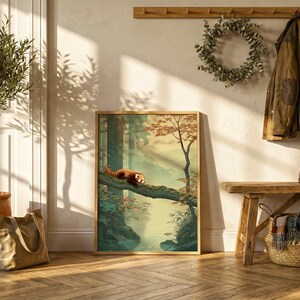 May include: A framed art print depicts a red panda resting on a tree branch in a forest scene. The artwork features a warm color palette with shades of green, brown, and orange. The print is displayed against a white wall with a wooden bench and coat rack.