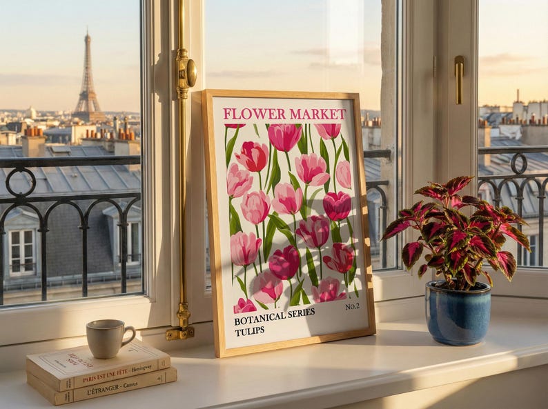 May include: A framed print with a floral design featuring pink tulips, labeled "FLOWER MARKET" and "BOTANICAL SERIES TULIPS." The print is displayed on a windowsill with a view of the Eiffel Tower and a small potted plant.