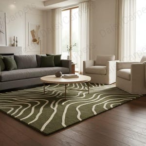 May include: A living room scene featuring a green rug with a white wave pattern, a gray sofa with green pillows, two beige armchairs, and a round wooden coffee table. The room has large windows and neutral-toned walls.