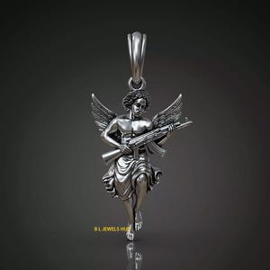 Puede incluir: Colgante de plata que representa un &aacute;ngel alado sosteniendo un rifle de asalto. El &aacute;ngel est&aacute; representado en un estilo cl&aacute;sico, con alas detalladas y t&uacute;nicas fluidas. El colgante tiene un lazo para una cadena.