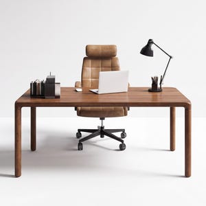 Puede incluir: Un escritorio rectangular de madera con esquinas redondeadas y cuatro patas cilíndricas. Una silla de oficina de cuero color canela con respaldo acolchado se sitúa detrás. Sobre el escritorio hay un portátil blanco, una lámpara negra y un portalápices.