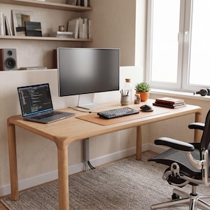 May include: A light wood desk featuring a laptop with code on the screen, a large monitor on a silver stand, a mechanical keyboard, a computer mouse, a desk mat, a small potted succulent, a glass bottle, and a black office chair with wheels.