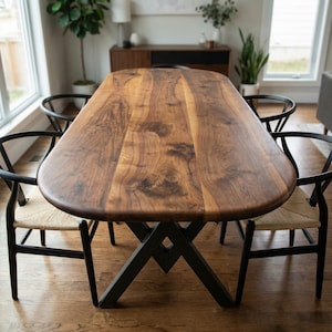 Mesa de comedor de madera de nogal, borde natural, estilo rústico, base negra.