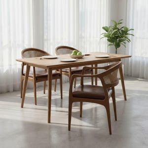Pode incluir: Uma mesa de jantar de madeira com quatro cadeiras. As cadeiras t&ecirc;m assentos de couro castanho e encostos de palhinha tecida. A mesa &eacute; retangular e tem um acabamento em madeira clara. H&aacute; pratos e uma tigela com ma&ccedil;&atilde;s verdes na mesa.