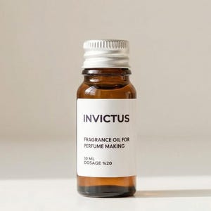May include: A small, brown glass bottle with a silver cap. The label reads "Invictus, Fragrance Oil for Perfume Making, 10 ml, Dosage %20". The bottle is filled with a golden liquid.