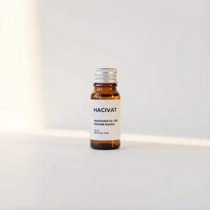 May include: A small amber glass bottle with a silver cap. The label reads "HACIVAT" and "FRAGRANCE OIL FOR PERFUME MAKING". The bottle contains 10 ml of oil with a dosage of 3:30. The bottle is centered on a white background.