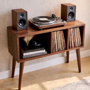 May include: A set of three ceramic mugs with a speckled, matte finish in cream, light grey, and dark grey. Each mug has a simple, minimalist design and a rounded handle.