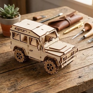 Peut inclure: Un modèle réduit de véhicule tout-terrain en bois clair, doté d'une carrosserie carrée, d'une calandre avant, d'un volant visible à travers la fenêtre et de quatre roues épaisses et texturées. Le modèle est fait de pièces en bois découpées au laser.