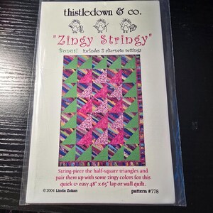 以下が含まれることがあります： thistledown & co. の「Zingy Stringy」というタイトルのキルトパターン。このパターンには、122cm x 165cmのラップまたはウォールキルトの指示が含まれています。キルトのデザインは、ピンク、緑、その他の色のハーフスクエアトライアングルが特徴です。