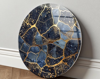 May include: A circular wall art piece featuring a deep navy blue and slate grey stone-like pattern. The surface is segmented by thin, reflective gold lines that mimic the appearance of kintsugi, accented with scattered gold flecks throughout.