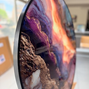 Angled detail of circular wall decor, flowing purple, copper and gray marble patterns, bold gold vein abstract marble wall art