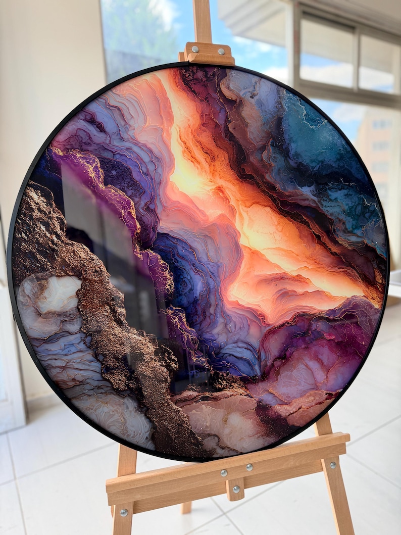 Round glass wall art on an easel, vivid purple and gold marble swirls, geode style, modern glass wall decor