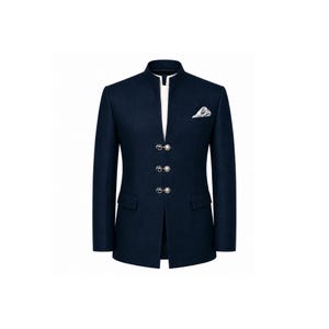 Könnte beinhalten: Ein dunkelblauer Blazer mit Stehkragen, weißer Innenleiste und drei silberfarbenen Zierknöpfen auf der Vorderseite. Die Jacke verfügt über zwei Pattentaschen in der Taille und ein weißes Einstecktuch in der Brusttasche.