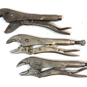 Op de afbeelding: Drie zilverkleurige metalen griptangen met gekartelde bekken en verstelbare stelschroeven. Elk gereedschap is voorzien van een hefboommechanisme voor het vastzetten en losmaken van de grip. De metalen oppervlakken vertonen gebruikssporen.
