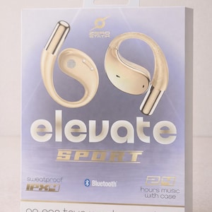 Può includere: Una scatola di auricolari true wireless on-ear color oro. La scatola presenta il marchio "elevate SPORT" in lettere dorate, insieme al logo "ZERO STATIK". La scatola indica anche che gli auricolari sono resistenti al sudore, compatibili con Bluetooth e offrono 20 ore di musica con la custodia.